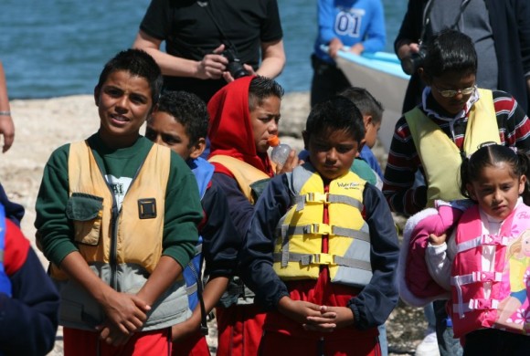 Students in life jackets getting off of boats.